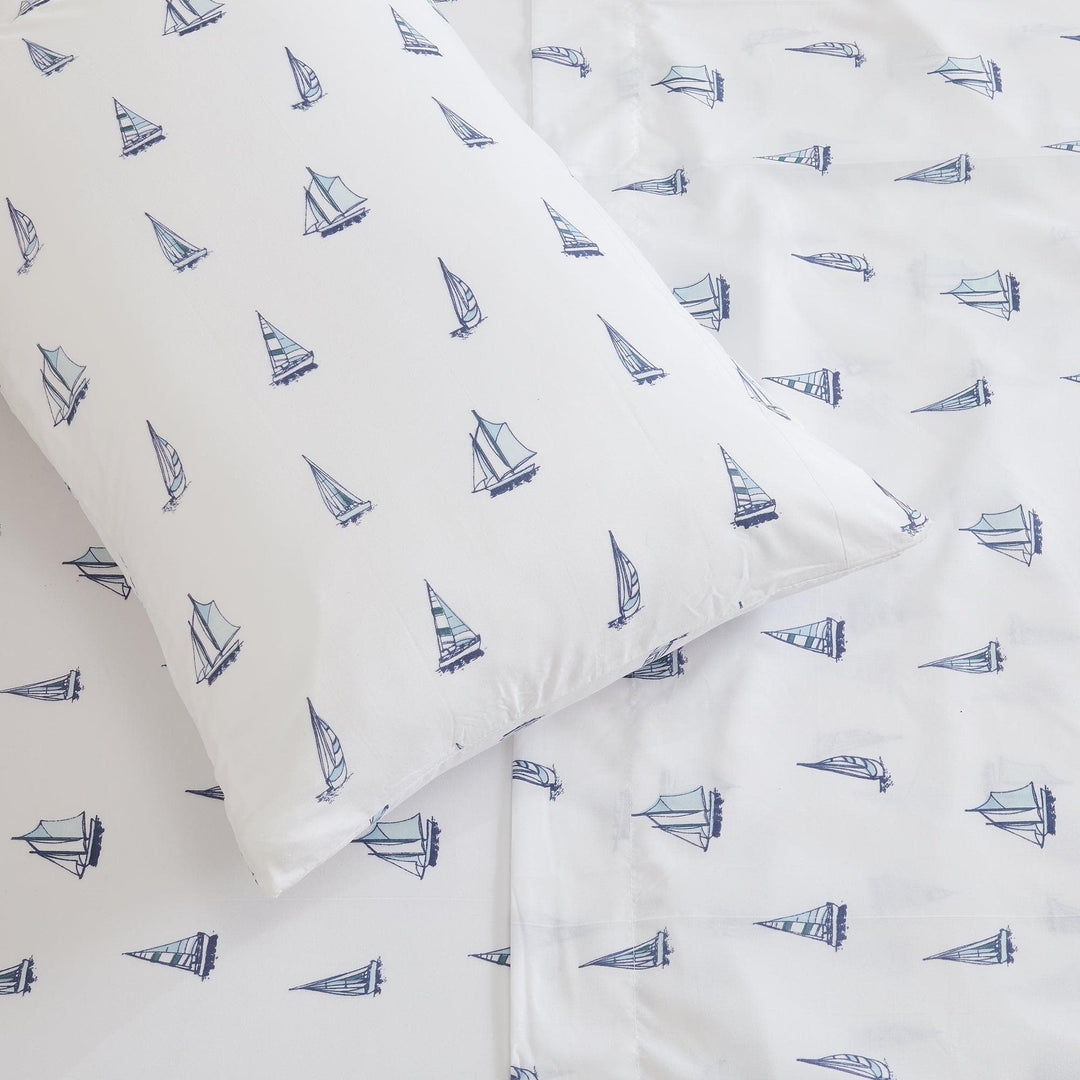 Sheet set with blue sailboat pattern on white fabric