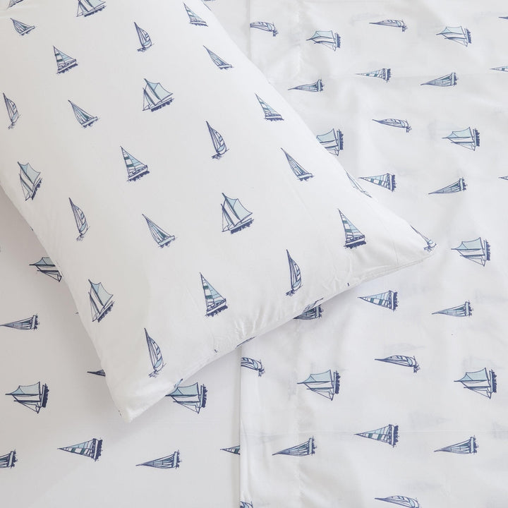 Sheet set with blue sailboat pattern on white fabric