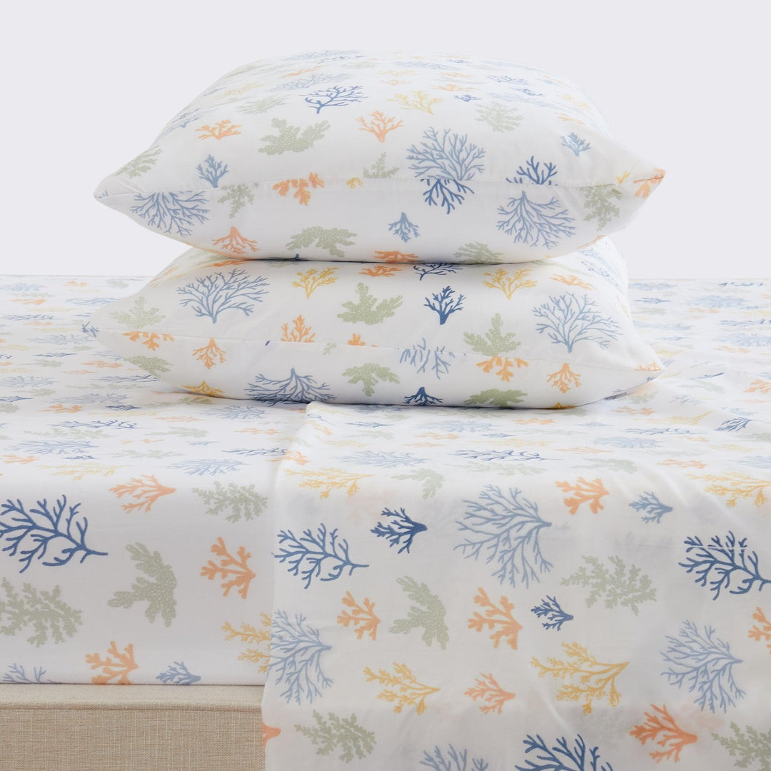 Floral-patterned bed sheets and pillows on a white background