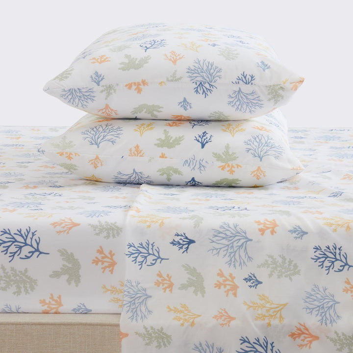 Floral-patterned bed sheets and pillows on a white background