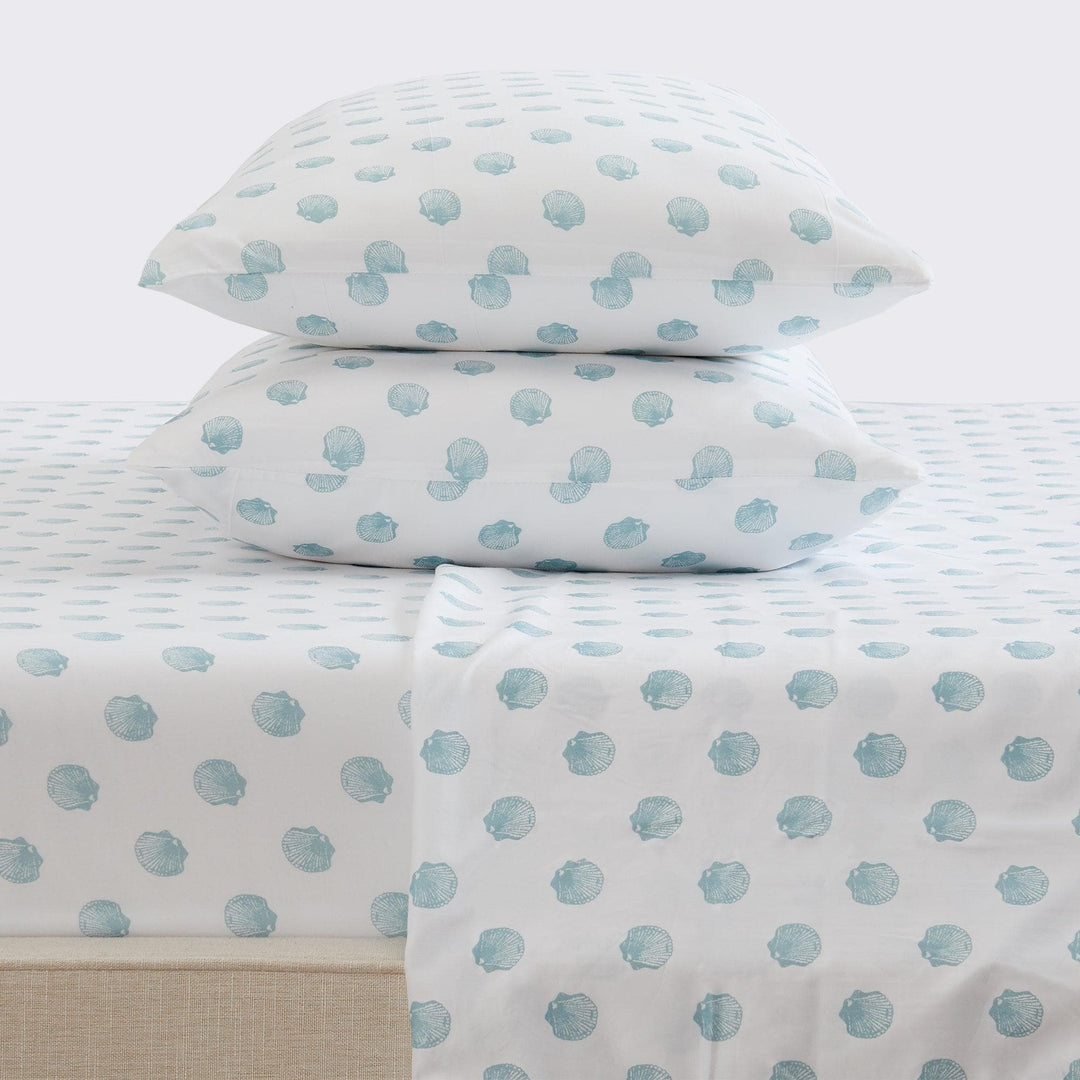 Sheet set with blue seashell pattern on a bed