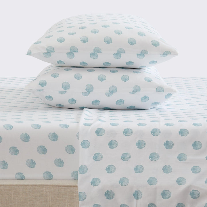 Sheet set with blue seashell pattern on a bed