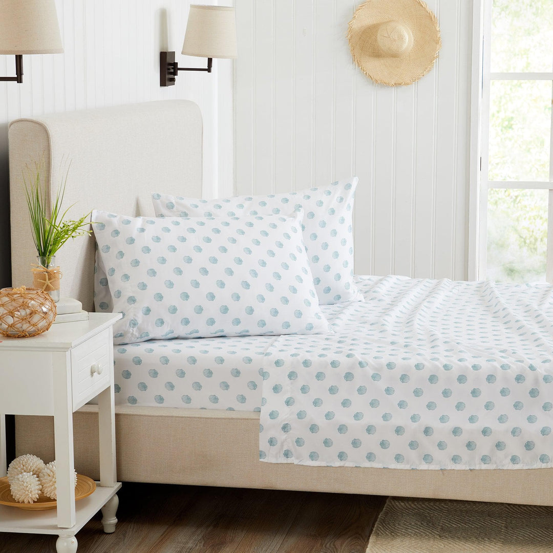 Bed with blue seashell bedding in a bright bedroom setting