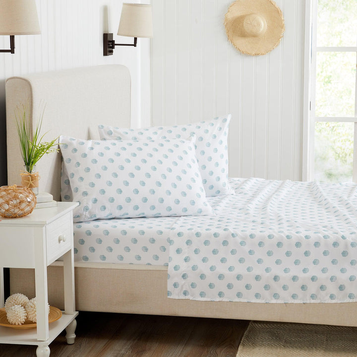 Bed with blue seashell bedding in a bright bedroom setting
