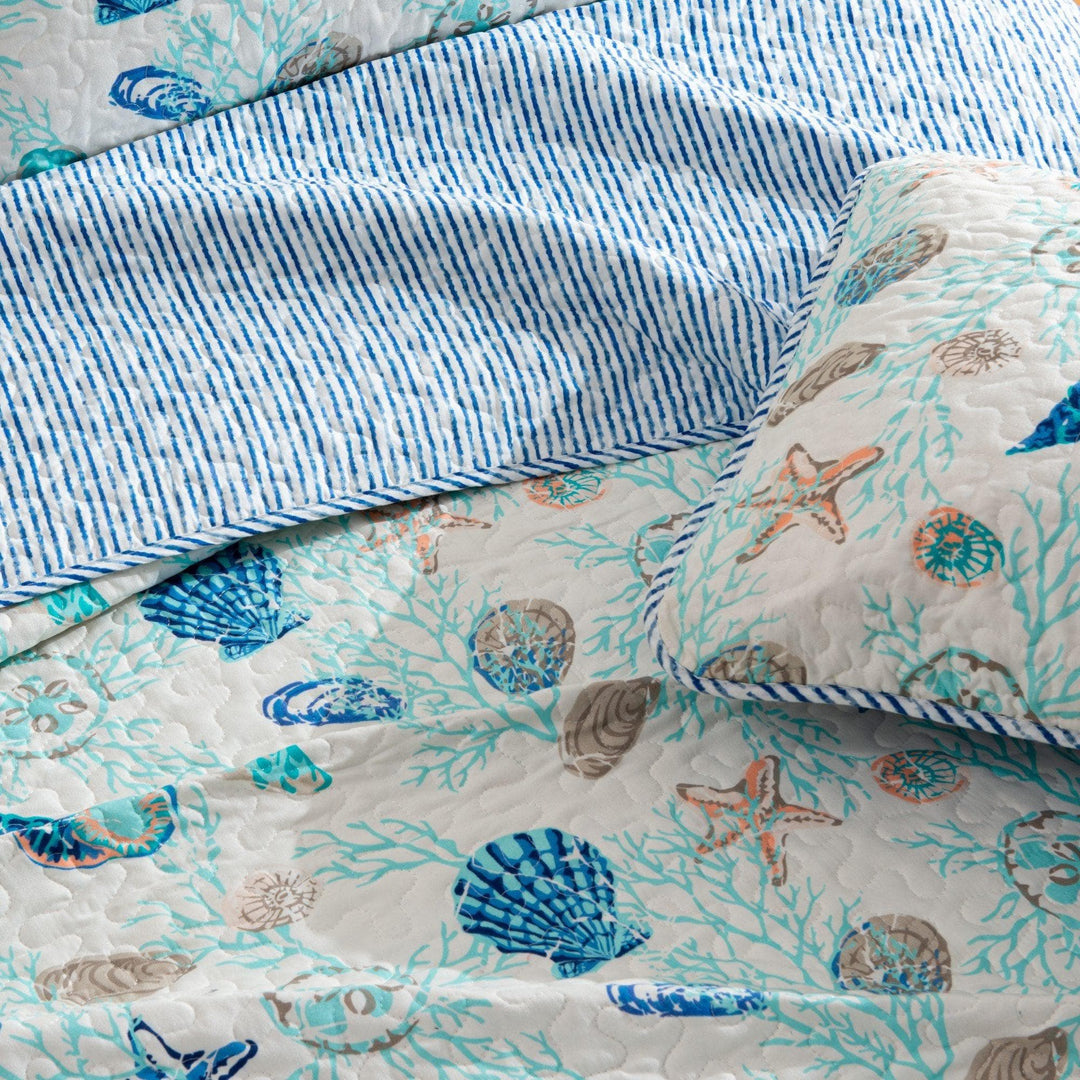 Quilt with seashell and starfish pattern with reverse blue stripe pattern