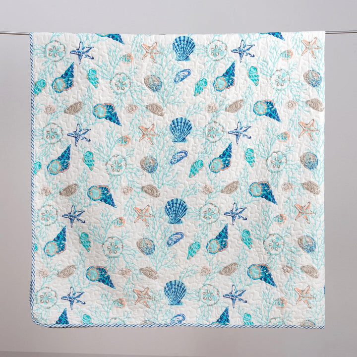 Quilt with a sea-themed pattern featuring shells and starfish on a light blue background.
