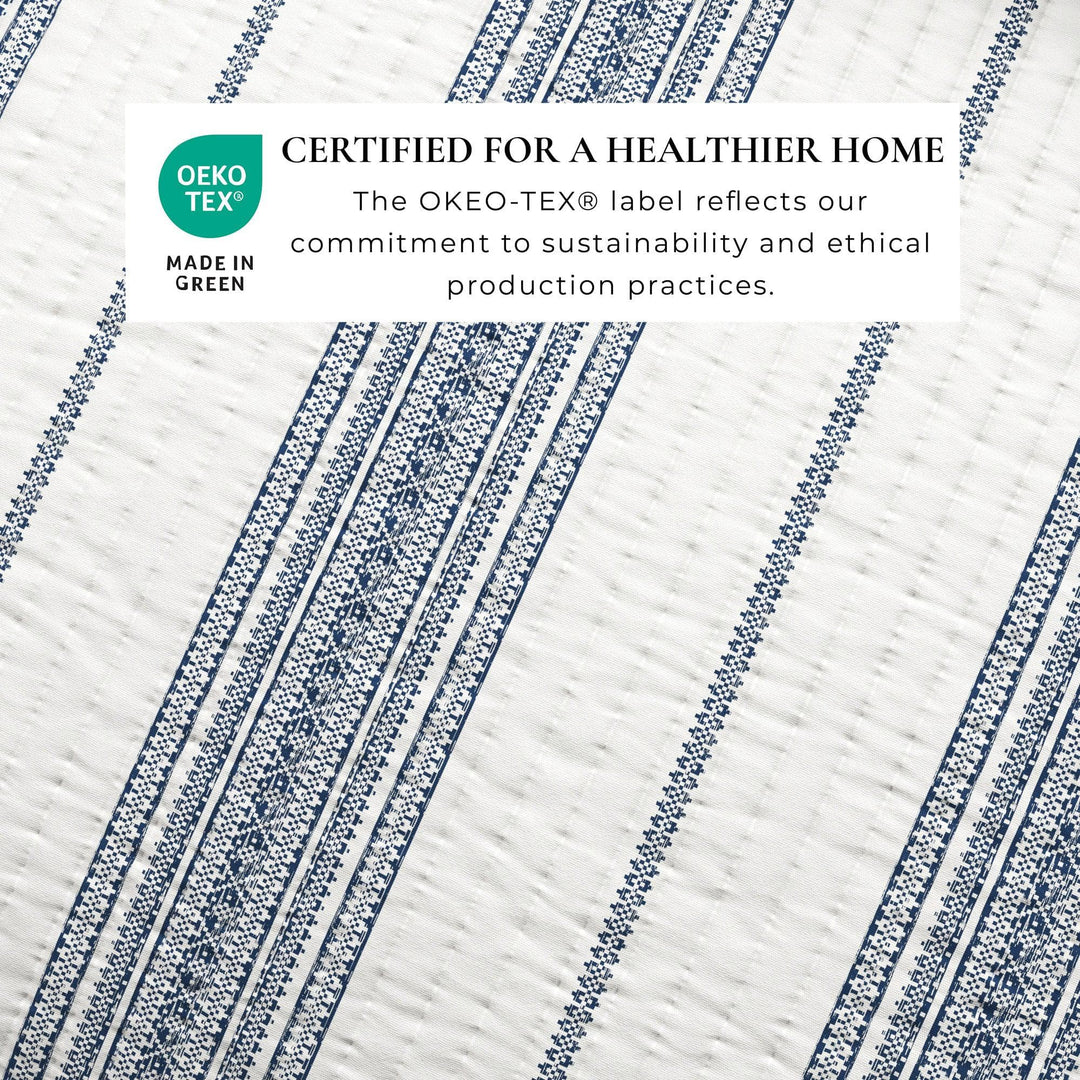 Textile with blue and white patterns and OEKO-TEX certification label on a white background