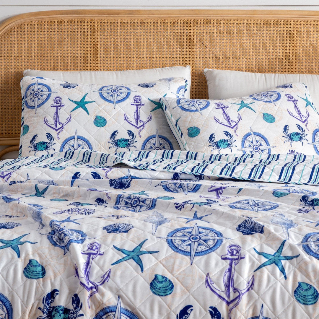 Nautical-themed bedding set with anchors, stars, and compasses on a white background.