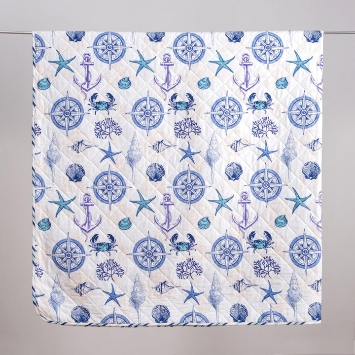 Nautical-themed quilt with blue anchors, stars, and compasses on a white background
