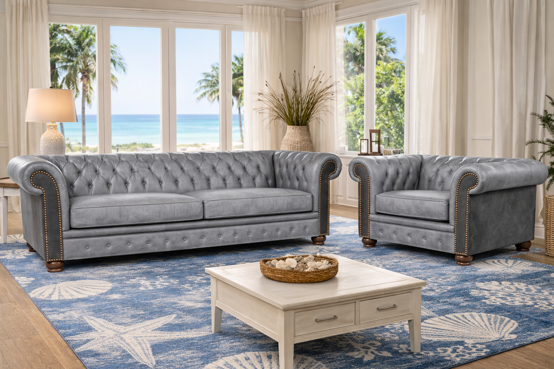 Harbor Fog Grey Chesterfield Leather Furniture in coastal living room on a blue and white sea shell rug with a view of the ocean 