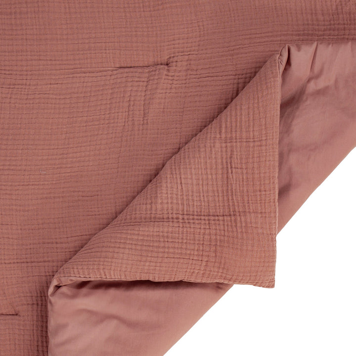 Close-up of voile cotton clay textured bedding fabric with a white background