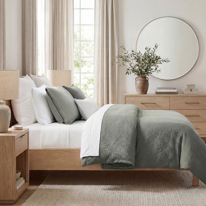 Neatly made Voile cotton bedding set in sage with white sheets in a bedroom setting.