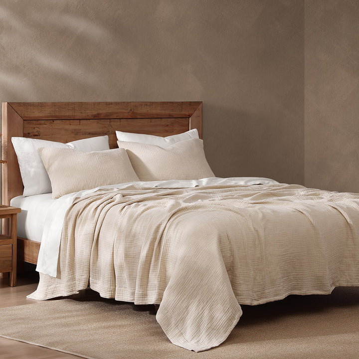 voile cotton sable bedding set on a wooden bed with a neutral wall background
