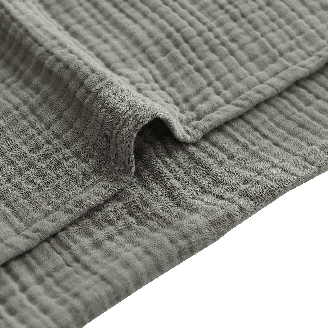 Close-up of a voile cotton sage textured fabric with a white background