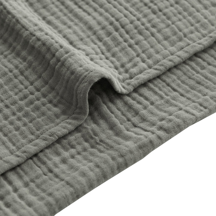 Close-up of a voile cotton sage textured fabric with a white background