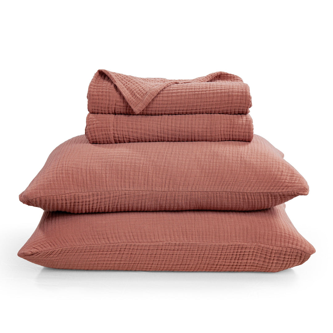 Stack of voile cotton bedding set in Clay textured on a white background