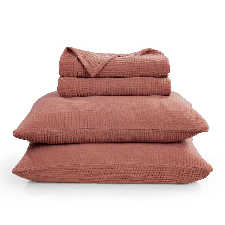 Stack of voile cotton bedding set in Clay textured on a white background