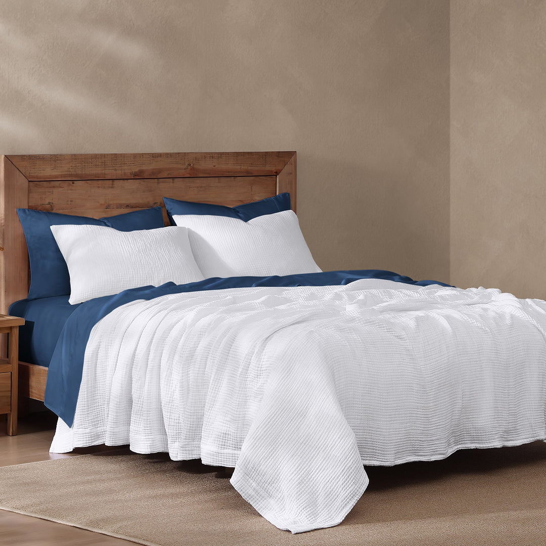 voile cotton blanket in white and blue sheets against a beige wall
