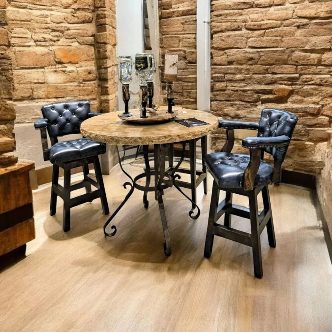 Blue leather tufted swivel bar chair at a travertine and iron pub table in rustic bar area 